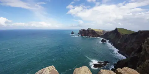 Steile Klippen und das weite Meer vor Madeira im Oktober. Das Wetter ist wechselhaft, aber die Aussicht ist atemberaubend.