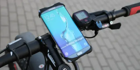 Jaki uchwyt na telefon do roweru? Samsung Galaxy S6 edge+ zamontowany na kierownicy roweru, obok licznika.