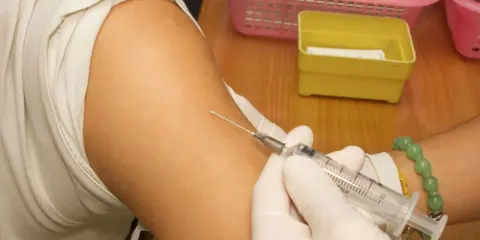 Spritze wird in den Arm einer Person eingeführt, die eine Hyposensibilisierung gegen Asthma erhält.
