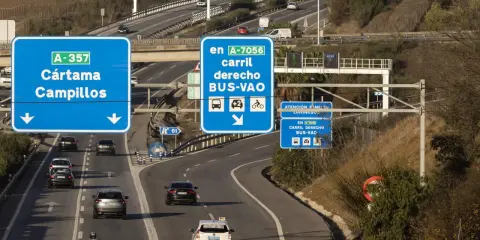 Carril derecho BUS-VAO en A-7056, con distintivo ambiental B. Señalización de tráfico en autopista.