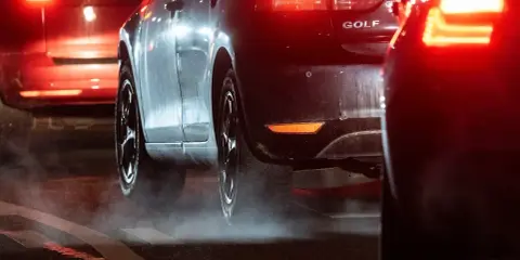 Autos im Stau, rote Rücklichter leuchten. Ein Golf-Modell. Vielleicht ein Vorgeschmack auf das China Verbrenner Verbot?