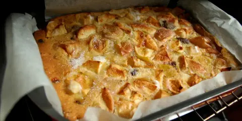 Bustrengo riminese appena sfornato, con mele dorate e zucchero croccante. Un dolce della tradizione romagnola.