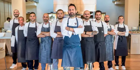 Il team di chef posa con orgoglio, pronto a servire esperienze culinarie d'eccellenza nei ristoranti stellati di Rimini.