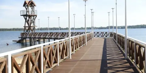 Drewniany pomost z wieżą ratowniczą i latarniami to idealne atrakcje nad jeziorem.