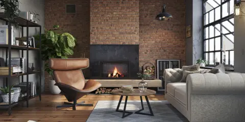 Przytulny salon w stylu loft. Ceglana ściana, kominek, skórzany fotel i wygodna kanapa – idealne salon loft inspiracje.