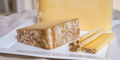 Tranches de Cantal, une des spécialités du Cantal, sur une assiette blanche.