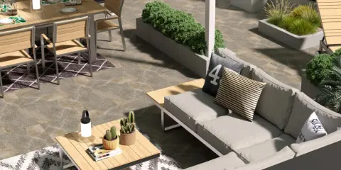 Un elegante giardino pavimentato moderno con divano, tavolo da pranzo e piante.