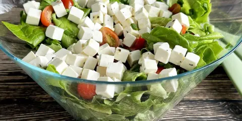 Rewelacyjna sałatka na grilla: chrupiąca sałata, soczyste pomidorki i kostki sera feta. Idealna na letnie przyjęcie!