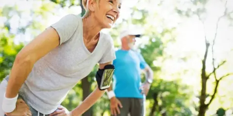 Glückliche Frau und Mann beim Joggen im Alter im Park. Sie genießen die Natur und die Bewegung.