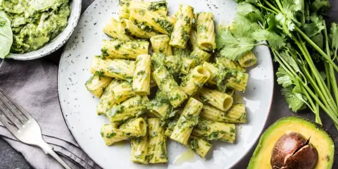Pyszny makaron z pesto, podany z awokado i świeżymi ziołami. Idealny na szybki obiad.