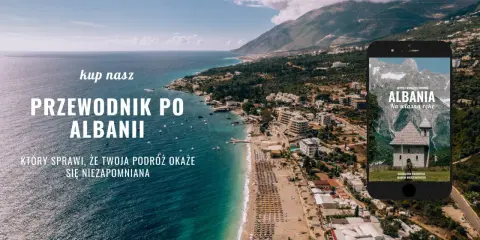 Przewodnik po Albanii, który sprawi, że Twoja podróż będzie niezapomniana. Widok na wybrzeże i góry, z telefonem prezentującym okładkę książki o Albanii.
