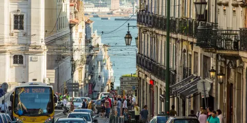 Ein belebter Tag in Lissabon, wo die portugiesischen Einwohner die engen Gassen mit ihren historischen Gebäuden und dem Blick auf das Wasser beleben.