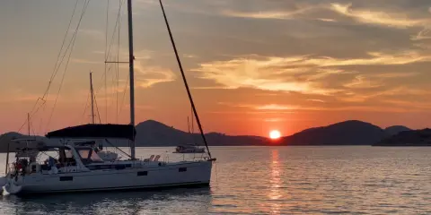 Voiliers au coucher du soleil, une scène paisible pour apprendre comment mouiller rapidement.