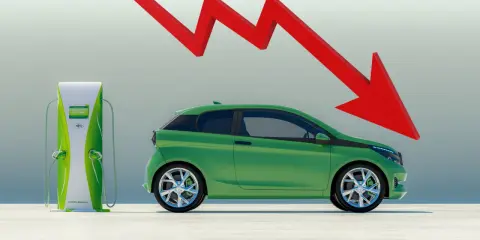 Freccia rossa in picchiata su un'auto elettrica verde vicino a una colonnina di ricarica, simbolo di un flop.