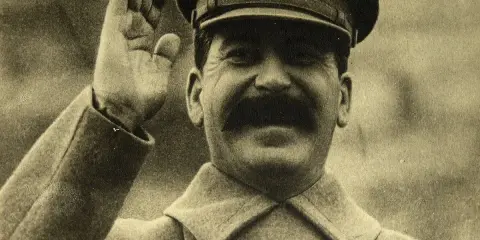 Józef Stalin w mundurze, salutujący. Jego śmierć, na co zmarł Stalin, wciąż budzi dyskusje.