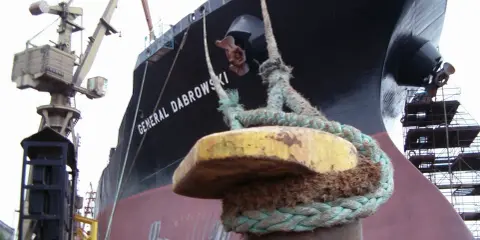 Gros plan sur une aussière, définition de l'amarrage d'un navire, le "GENERAL DABROWSKI", au port. Grues et échafaudages en arrière-plan.