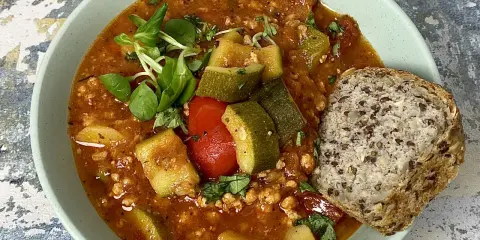 Gulasz z cukinii i pomidorów z mielonym mięsem, podany z chlebem pełnoziarnistym. Idealne danie, gdy zastanawiasz się, co zrobić dobrego na obiad.