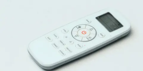 Telecomando bianco con vari simboli condizionatore: ON/OFF, temperatura, modalità, timer, sleep, smart, quiet, dimmer, economy.