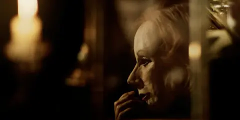 En närbild av en kvinna med en drömmande blick, som påminner om Greta Garbos ikoniska roller i klassiska filmer.