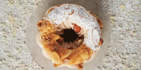 Un Paris-Brest aérien, garni d'une crème onctueuse et décoré d'amandes effilées. Le praliné pour Paris-Brest est ici sublimé.