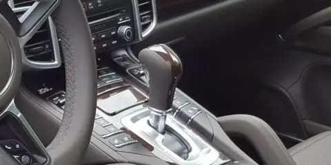 Elegancka skrzynia biegów automatyczna w luksusowym samochodzie. Drewniane wykończenia i chromowane detale podkreślają jej prestiż.