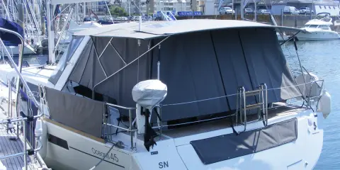 Bateau avec taud de soleil intégral, offrant une protection complète. La différence entre bimini et taud de soleil est claire : le taud couvre plus.