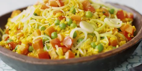 Bunter Reis mit Erbsen, Karotten und Lauchringen, inspiriert von Safran-Rezepten.