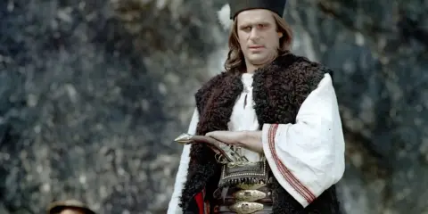 Mężczyzna w tradycyjnym stroju góralskim, z pistoletem przy pasie. Czy to słynny Janosik, kto to taki?