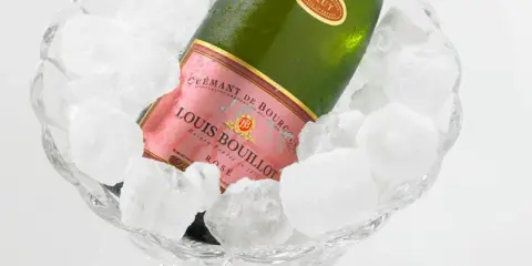 Flasche Louis Bouillot Rosé Crémant de Bourgogne in Eis gekühlt, perfekte Champagner Temperatur.