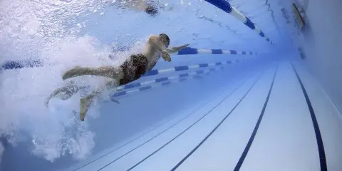 Pływak w soczewkach pokonuje tor w basenie. Czy w soczewkach można pływać? Tak, ale ostrożnie.