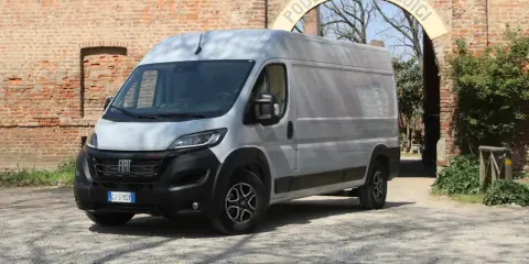 Srebrny Fiat Ducato Maxi stoi przed ceglanym murem i łukiem z napisem "PODERE S. LUIGI".