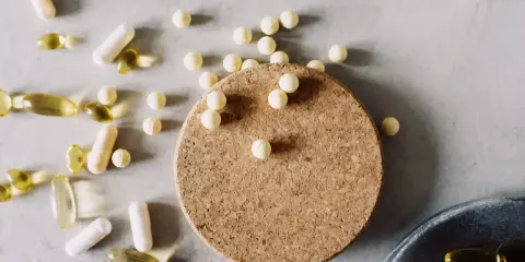 Kapseln und Pillen, darunter auch solche, die bei **Magnesium zum Abnehmen** helfen könnten, liegen verstreut auf hellem Untergrund.