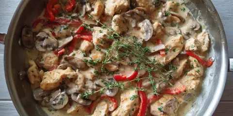 Kyckling i en krämig creme fraiche sås med champinjoner och paprika, toppad med färsk timjan.