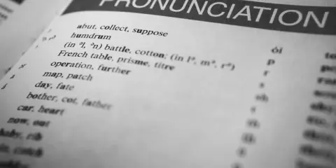 Otwarta książka z hasłem "PRONUNCIATION". Lista słów i symboli fonetycznych pokazuje, czy angielski jest trudny.