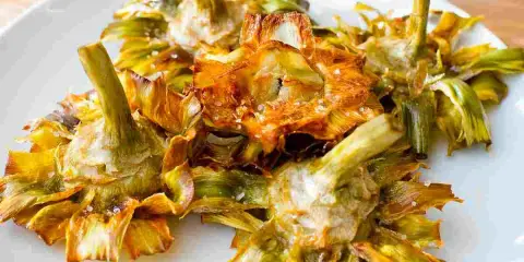 Carciofi fritti croccanti su un piatto bianco, un modo delizioso per imparare come cucinare i carciofi.
