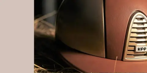 Brązowy kask jeździecki KEP Italia z metalicznym elementem i logo.