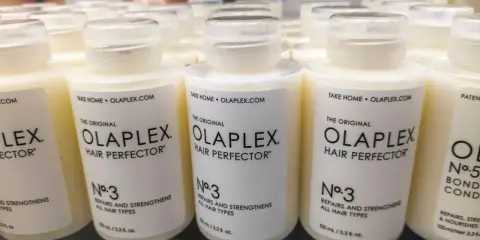 Reihen von Olaplex Hair Perfector No. 3 Flaschen, die bei Haarausfall helfen.