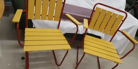 Två gula och röda **grythyttan stolar gamla modeller** står bredvid varandra.
