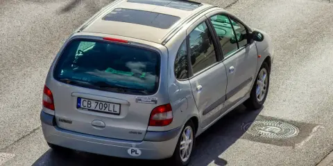 Srebrny Renault Scenic z naklejką "Ubezpieczony przez mafię". Szybkie auta i zimna noc, jak w tekstach SB MAFFIJA.