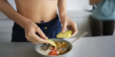 Idealne co jeść po treningu: jogurt z granolą, owocami i nasionami. Zdrowy posiłek dla regeneracji.