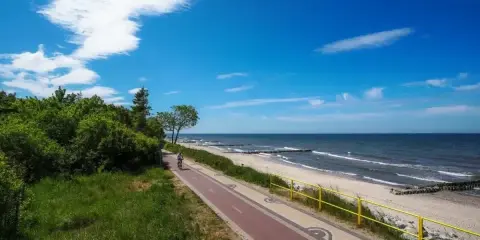 Piękny dzień nad polskim morzem. Ścieżka rowerowa wzdłuż plaży, idealna na wakacje.