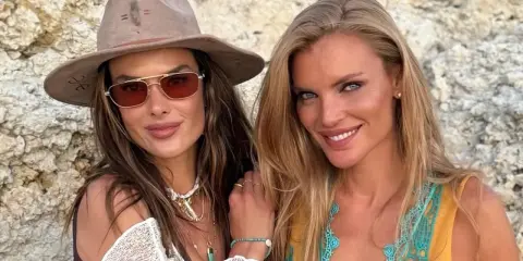 Alessandra Ambrosio y una amiga sonríen a la cámara, luciendo gafas de sol y joyas veraniegas.