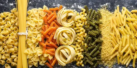 Assortiment de pâtes : spaghetti, farfalle, fusilli, tagliatelle, penne et vermicelles. Un festin de pâtes au blé complet pour tous les goûts.