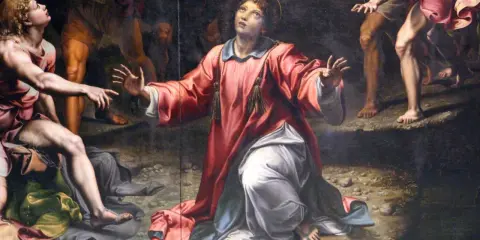 Painting of a saint in a red robe kneeling and looking up, with other figures around.