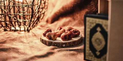 Datteln und ein Koran symbolisieren das Ende des Ramadan. So feiert man warum feiert man zuckerfest.