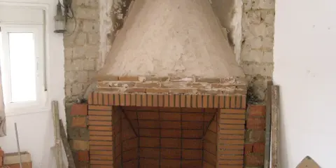 Construcción de chimenea de obra. El hogar de ladrillo y la campana cónica de cemento están en proceso. Aprende como hacer una chimenea de obra que no haga humo.