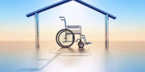 Fauteuil roulant sous un toit stylisé, symbolisant le logement PMR en location.