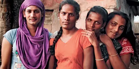 Cztery osoby, które identyfikują się jako trzecia płeć w Indiach, pozują do zdjęcia.