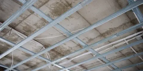 Szkielet sufitu podwieszanego podwójnego z widocznymi przewodami elektrycznymi.