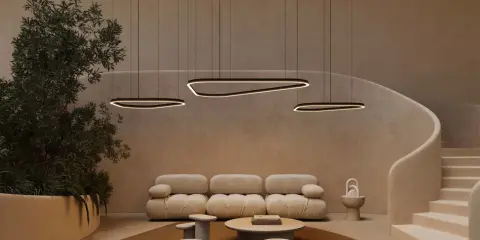 Un salon moderne avec un plafond cathédrale, des suspensions lumineuses organiques, un canapé moelleux et un escalier incurvé.